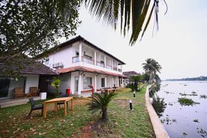 a building next to a body of water at Vedic Village Retreat Alleppey in Alleppey