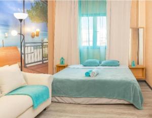 a bedroom with a bed with blue pillows and a couch at Arguinegin Gran Canaria Near the Beach with ocean view in Arguineguín