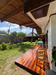 un portico con una terrazza in legno con un tetto di Surf House Palawan a San Vicente Altre 19 foto