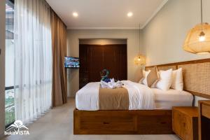 a bedroom with a large bed and a television at Soocha B by Bukit Vista in Ungasan