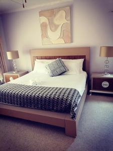 een slaapkamer met een bed met twee nachtkastjes en twee lampen bij 850 Munro in Margate