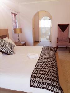 een slaapkamer met een bed, een stoel en een spiegel bij 850 Munro in Margate