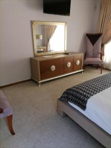 een slaapkamer met een bed en een dressoir met een spiegel bij 850 Munro in Margate