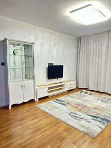 un soggiorno con una TV a schermo piatto su una parete di Dino guest house a Dalandzadgad