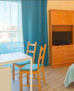 a dining room with a table and two chairs and a tv at Arguinegin Gran Canaria Near the Beach with ocean view in Arguineguín