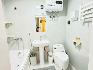 un bagno bianco con lavandino e WC di Dino guest house a Dalandzadgad