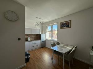 una cucina e una sala da pranzo con un tavolo e un orologio di Dino guest house a Dalandzadgad