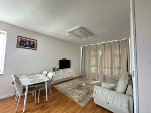 un soggiorno bianco con tavolo e divano di Dino guest house a Dalandzadgad