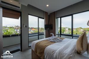 a bedroom with a bed and a balcony with windows at Soocha C by Bukit Vista in Ungasan +5 photos