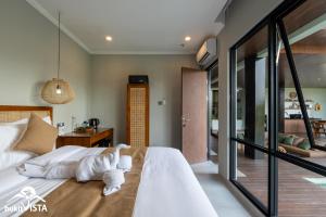 a bedroom with a large white bed and a balcony at Soocha C by Bukit Vista in Ungasan