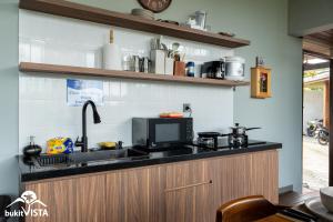 a kitchen with a sink and a microwave at Soocha C by Bukit Vista in Ungasan