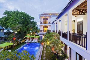 uma vista exterior de um resort com uma piscina em Paradise Indochine Hoi An em Hoi An