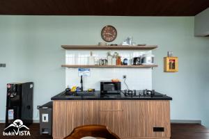 a kitchen with a stove and a clock on the wall at Soocha C by Bukit Vista in Ungasan