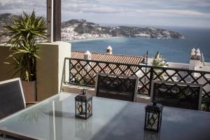a glass table on a balcony with a view of the ocean at Casa José in La Herradura