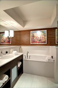 a bathroom with a bath tub and a sink at City Loft Hotel in Beaufort