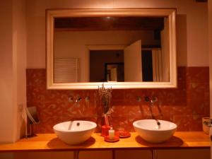 a bathroom with two white sinks and a mirror at B&B Via Punta 8 in Bologna