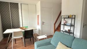 a living room with a blue couch and a table at La Rollinoise in Valsonne