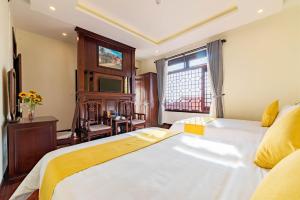 um quarto com uma grande cama branca e uma janela em Paradise Indochine Hoi An em Hoi An