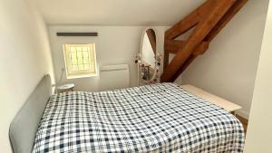 a bedroom with a bed with a checkered blanket at La Rollinoise in Valsonne