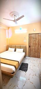a bedroom with a bed with a ceiling fan at HOTELLEOs in kolkata
