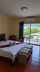 a bedroom with a large bed and a large window at The Sunshine hostel and hotel in Ko Lanta +91 photos