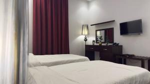 的黎波里فندق الجرات的有两张床和一面镜子的酒店房间