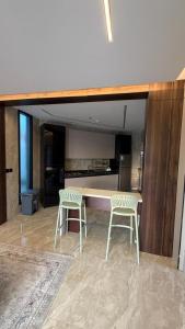 una cucina con due sedie bianche e un tavolo di شاليهات ستارفيش a Umm Lajj