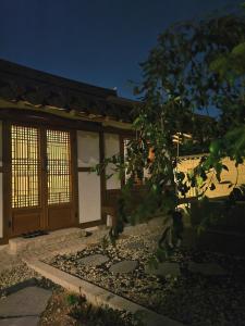 una casa con una porta e un albero di fronte di 사다함 SaDaHam a Gyeongju