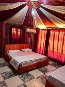 a bedroom with a bed in a tent at Rotana camp in Disah