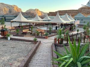 a group of white tents with benches and tables at Rotana camp in Disah