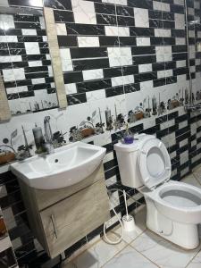 a bathroom with a white toilet and a sink at Rotana camp in Disah