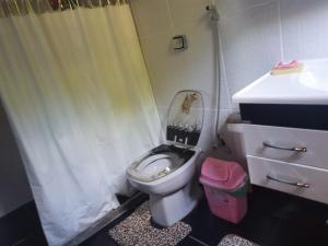 a bathroom with a toilet with a shower curtain at Quarto privativo em Araruama in Araruama