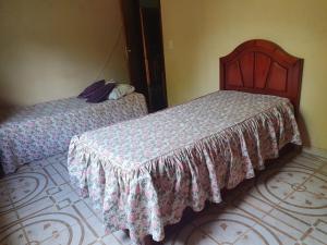 two beds sitting next to each other in a bedroom at Quarto privativo em Araruama in Araruama