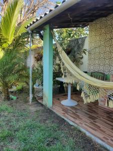 a hammock on a deck next to a house at Quarto privativo em Araruama in Araruama +10 photos