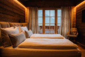 a bedroom with two beds and a window at Sissi green Chalets in Seefeld in Tirol