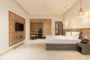 a bedroom with a large bed and a tv at The Aralia in Dehradun