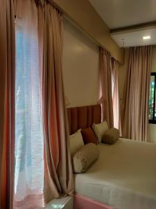 ein Schlafzimmer mit einem Bett mit Kissen und einem Fenster in der Unterkunft Coral Bay Villa in Jāmb