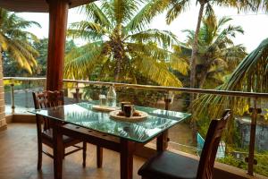 ein Tisch mit einer Tasse Kaffee auf einem Balkon mit Palmen in der Unterkunft Coral Bay Villa in Jāmb