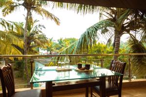 einen Tisch mit zwei Tassen auf einem Balkon mit Palmen in der Unterkunft Coral Bay Villa in Jāmb