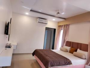 ein Hotelzimmer mit Bett und Fernseher in der Unterkunft Coral Bay Villa in Jāmb + 4 Fotos