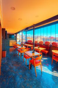 een restaurant met tafels, stoelen en ramen bij Kaya-Royal-Hotel Beyazit Istanbul All Tea And Coffee Are Complimentary And Available 24-7 On Our Sea View Terrace Restaurant in Istanbul