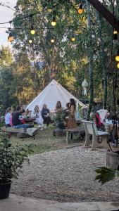 een groep mensen die rond een witte tent zitten bij Amazing Mountain Camping, Bar&Grill in Ban Pang Hai