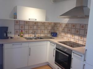 a kitchen with white cabinets and a sink and a stove at Haus Meßmer in Bad Dürrheim +6 photos