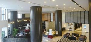 a lobby with columns and couches in a building at Hainan Junhua Haiyi Hotel in Haikou +253 photos