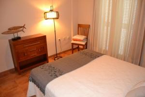 a bedroom with a bed and a dresser and a chair at Casa José in La Herradura