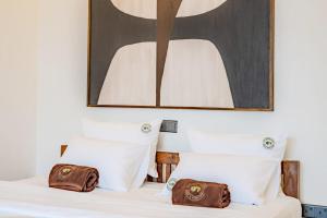 een bed met twee kussens en een schilderij erboven bij The Green Rooms Surf & Yoga Camp - ON THE BEACH - Prime location Renovated 2024 in Weligama