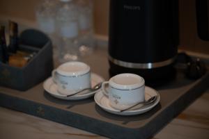 twee kopjes en schotels op een dienblad bij Asteria Melaka by Attic Suite in Melaka +85 foto's