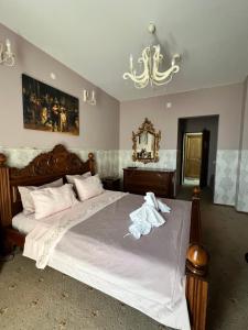 Un dormitorio con una cama con sábanas blancas y una lámpara de araña. en Pensiunea Baroc, en Brasov 93 fotos más