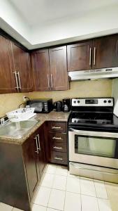 een keuken met houten kasten en een fornuis bij warm heart toronto in Toronto