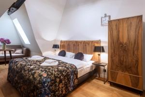 a bedroom with a large bed and a couch at Antique Apartments Plac Szczepański in Krakow